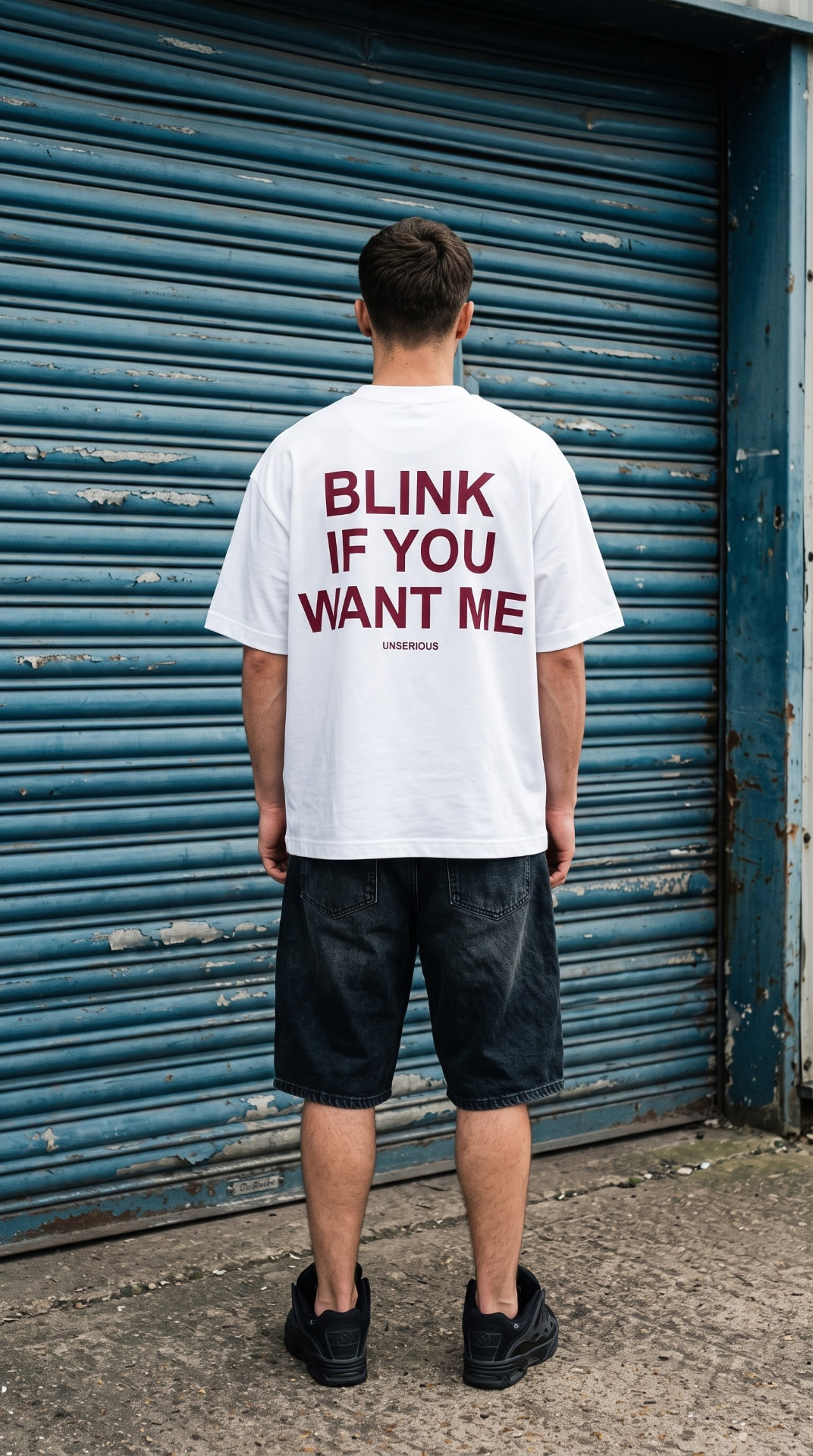 White Blink If You Want Me tee worn in front of a blue shutter